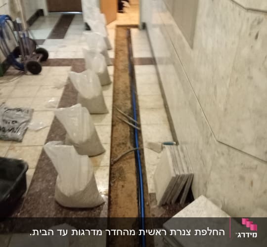 תעלה פתוחה עם צינור כחול וכלי עבודה